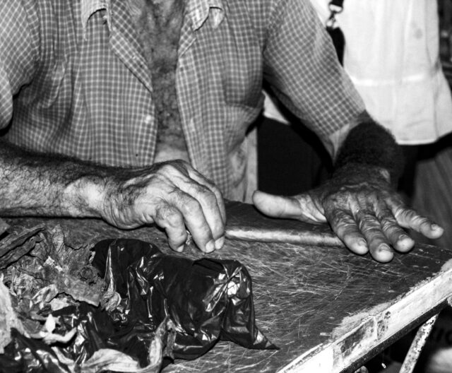 A Cuban tobacco farmer hand-rolling a cigar