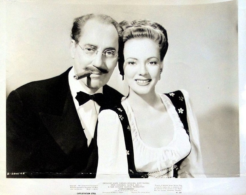 Groucho Marx holding a cigar with Gloria Jean in Copacabana (1947)