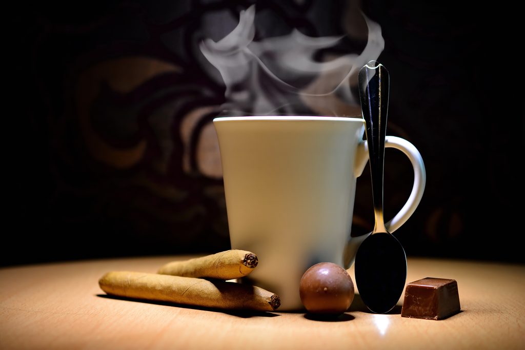Steaming coffee mug and cigars