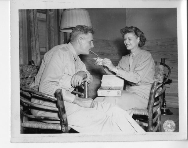 Lt. Mary Porter of the Women's Army Corps lighting a cigar for her father, 1943